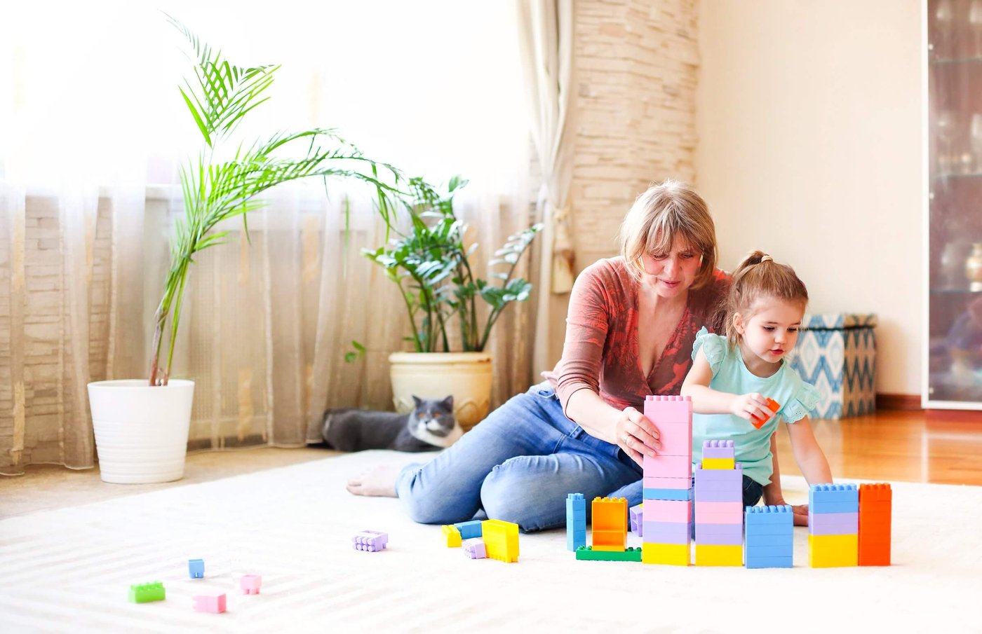 vecteezy-happy-grandmother-playing-with-granddaughter-on-floor-48586372